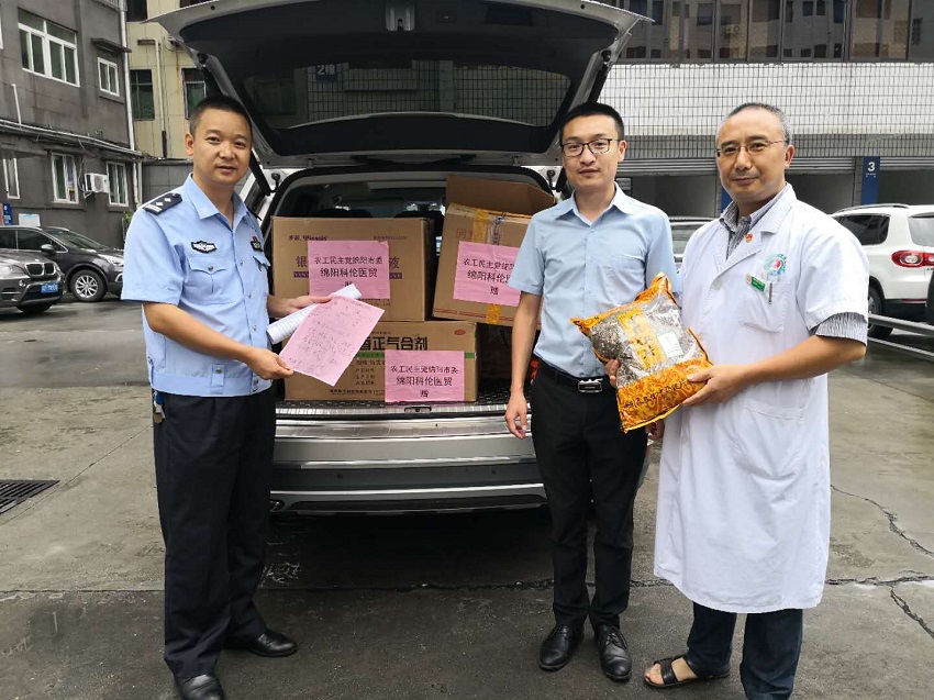 農工黨綿陽市委中醫藥支部副主委、科倫藥業公司總經理江國駟（中）向綿陽交警贈送醫療防疫物資.jpg